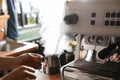 Barista steaming milk in metal jug with coffee machine wand at bar counter Royalty Free Stock Photo