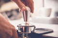 Barista tampering coffee in portafilter using tamper. Close-up fresh coffee preparation process Royalty Free Stock Photo