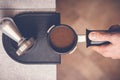 Barista tampering coffee in portafilter using tamper. Close-up fresh coffee preparation process Royalty Free Stock Photo