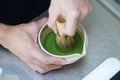 Barista Using bamboo whisk chasen stir matcha and hot water in the bowl on table, Mixing green tea in bowl Royalty Free Stock Photo