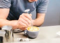 Barista using coffee machine preparing fresh coffee or latte art and pouring into white cup at coffee shop and restaurant, bar or