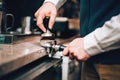 Barista using coffee machine preparing fresh coffee with latte foam at coffee shop and restaurant