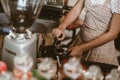 Barista using a tamper to press ground coffee into a portafilter. Coffee maker concept Royalty Free Stock Photo