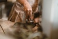 Barista using a tamper to press ground coffee into a portafilter. Coffee maker concept Royalty Free Stock Photo