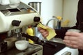 Barista wipes out leftover drops of milk on coffee machine Royalty Free Stock Photo