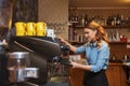 Barista woman making coffee by machine at cafe