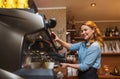 Barista woman making coffee by machine at cafe