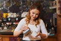 Barista woman pouring cream to cup at coffee shop