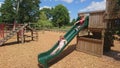 Wood chippings and children sliding down a green slide