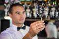 Barkeeper checking a wine glass