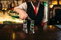 Barkeeper pouring alcoholic beverage in glass