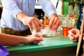 Barkeeper putting hard liquor glasses on bar