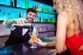 Barkeeper serving cocktail to young woman