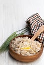 Barley groats porridge in wooden bowl on white table Royalty Free Stock Photo