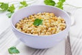 Barley porridge in a bowl with meat, vegetables and green parsley