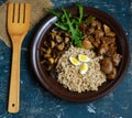 Barley porridge, fried mushrooms and duck liver, boiled quail eggs, tomatoes, arugula Royalty Free Stock Photo