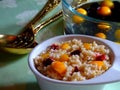 Barley porridge with plum and cherry on the background of cutlery