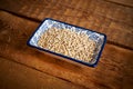 Barley porridge in a white ceramic bowl on an wooden table Royalty Free Stock Photo