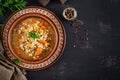 Barley soup with carrots, tomato, celery and meat on a dark background. Royalty Free Stock Photo
