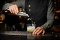 Barman adding an ice into the glass with a cane sugar and lime Royalty Free Stock Photo