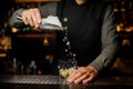 Barman adding ice into the glass with a cane sugar and lime Royalty Free Stock Photo