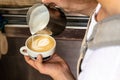 Barman adding some foam on a cappuccino