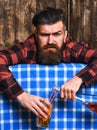 Barman with beard and painful grimace face holds cocktail