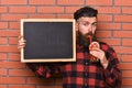 Barman with beard and pensive face drinks cocktail