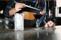 Barman decorating alcoholic cocktail at counter in pub