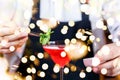 Barman decorating cocktail at a nightclub. Nightlife and entertainment concept with festive bokeh lights