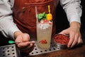 Barman is decorating cocktail with pink pepper Royalty Free Stock Photo