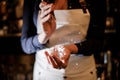 Barman girl crushing a piece of ice for making a cocktail