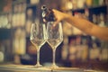 Girl bartender pours wine into a wine glass