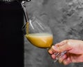 Barman hand at beer tap pouring a draught beer in glass serving