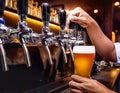 barman hand at beer tap pouring draught lager beer serving Royalty Free Stock Photo