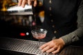 Barman hand pouring alcoholic drink with campari into the cocktail glass Royalty Free Stock Photo