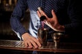 Barman hand pouring a portion of pink alcohol drink into the shaker