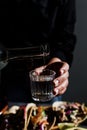 Barman hand serving mexican mezcal shot drink in a traditional glass in Mexico city