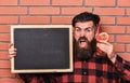 Barman, hipster holds cocktail and advertising. Man holds glass