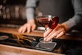 Barman holding a glass of red decorated alcoholic drink Royalty Free Stock Photo