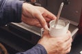 Closeup of barmen hand steaming milk in cafe