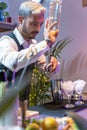 Barman making cocktail Mojito in night club adding ingredients and creating expert drinks on bar counter. Vertical shot. Royalty Free Stock Photo