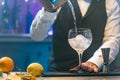 Barman making cocktail in night club adding ingredients and creating expert drinks on bar counter copy space. Royalty Free Stock Photo