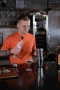 Barman is making cocktail at night club. stylish young man mixing a cocktail in a dark loft cafe. alcohol drink in