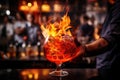 Barman is making a cocktail in a nightclub. Cocktail on fire. A glass of fiery cocktail on the bar counter against the background Royalty Free Stock Photo