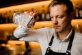 Barman mixing alcoholic cocktail with ice using strainer and glass Royalty Free Stock Photo