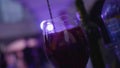 Barman mixing slice of orange into glass of cocktail. Frame. Dizzying stirring of slices of citrus in red wine cocktail