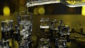 Barman pour frozen vodka from bottle into shot glass. Ice cubes against shiny gold party background Royalty Free Stock Photo