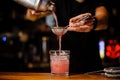 Barman poured an alcoholic cocktail from the shaker into a crystal glass Royalty Free Stock Photo