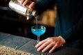 Barman pouring a fresh and sweet blue cocktail into a glass Royalty Free Stock Photo